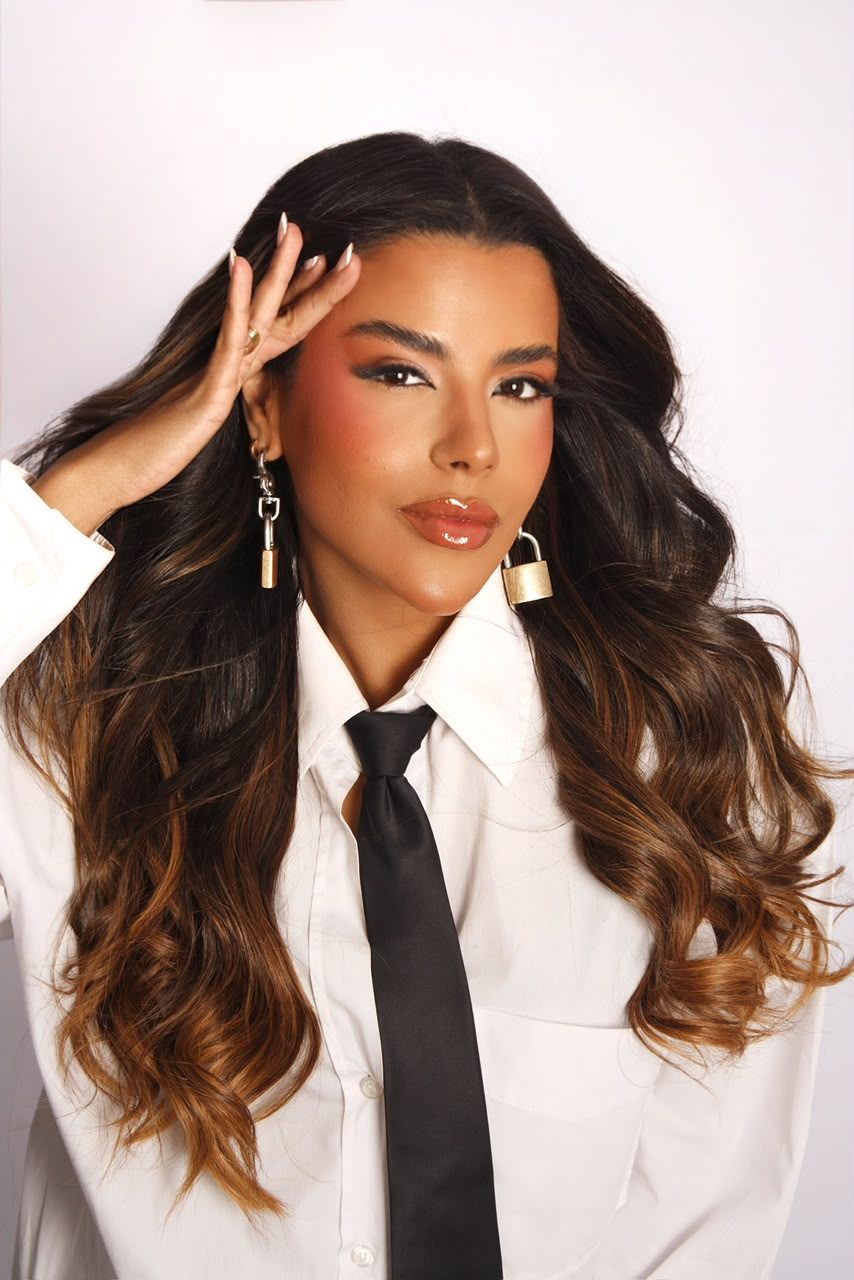 Retrato beauty de Juliana Cardoso com camisa branca, gravata preta e brinco de cadeado